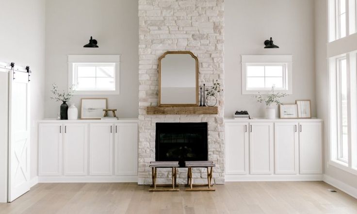 a living room with white furniture and a fireplace