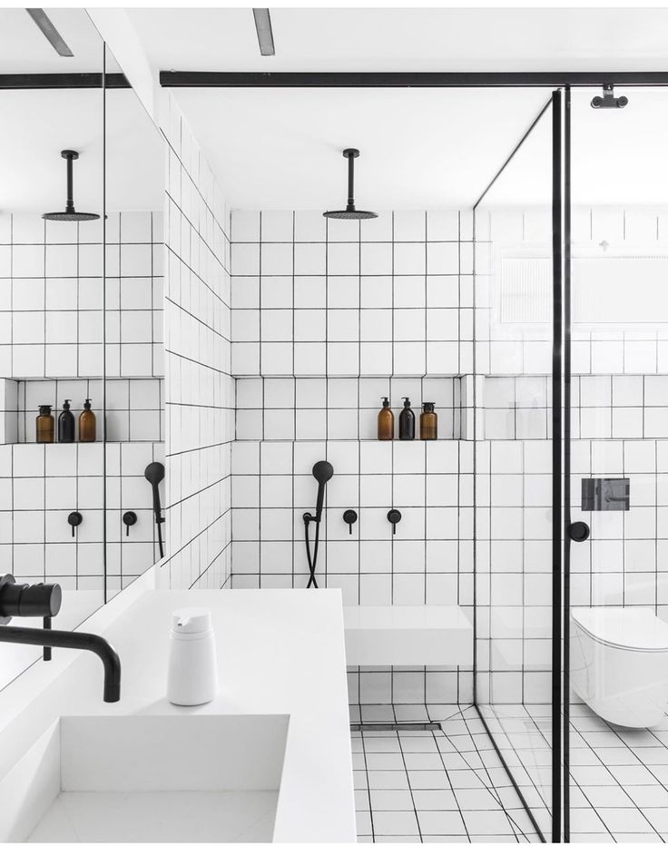 a white bathroom with black and white tiles