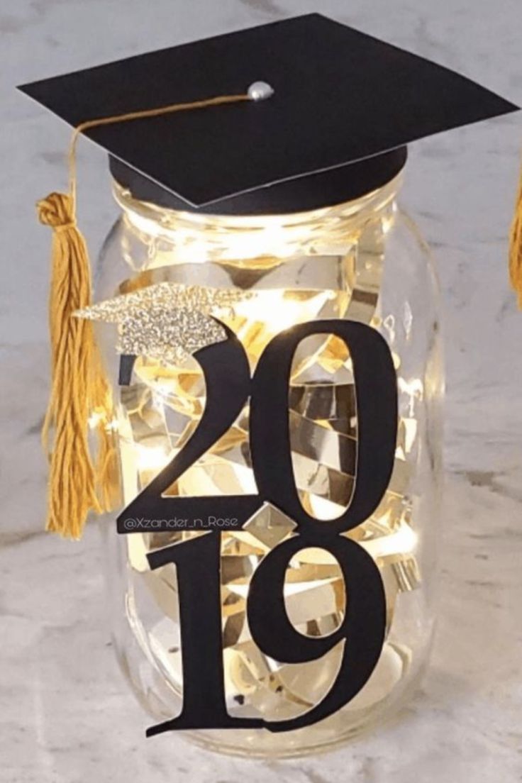 a graduation cap and tassel on top of a mason jar with the number 19 in it