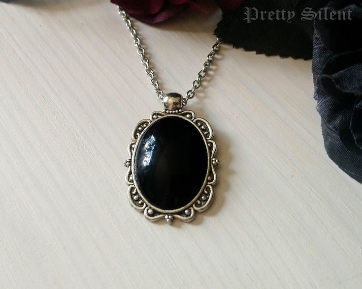 Handmade elegant, gothic style necklace  featuring a deep black glass cabochon that sits in a detailed antique silver ornate frame. Pendant size: 40 x 24 mm Cabochon size: 18 x 25 mm The necklace length can be chosen in the drop down menu.  Material: Antique silver plated metal alloy, glass cabochon All items come beautifully packaged. **PLEASE NOTE** : Standard Shipping is untracked to keep the shipping costs low. If you want to TRACK YOUR ORDER please select the SHIPPING UPGRADE at checkout! I Gothic Black Oval Jewelry, Black Oval Gothic Jewelry, Gothic Black Cabochon Jewelry, Black Gothic Cabochon Jewelry, Black Cabochon Victorian Jewelry, Victorian Black Cabochon Jewelry, Ornate Black Metal Necklace, Elegant Black Cabochon Necklace, Ornate Black Necklace For Formal Occasions