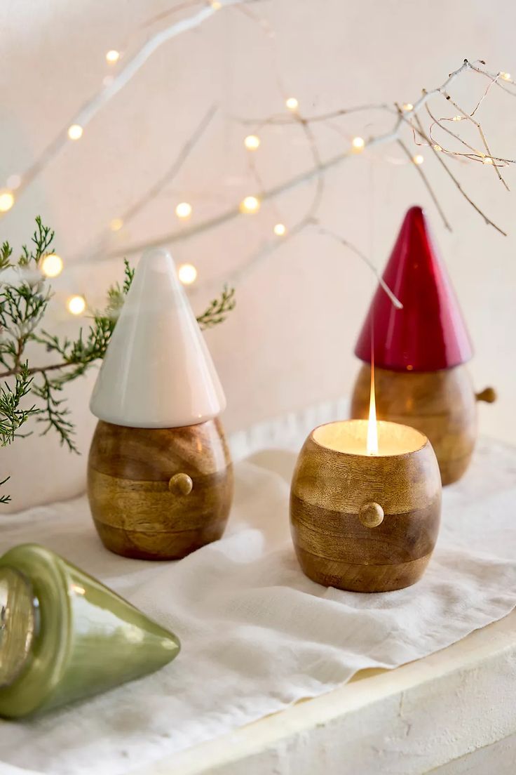 two wooden candles sitting on top of a table next to a vase with a candle in it