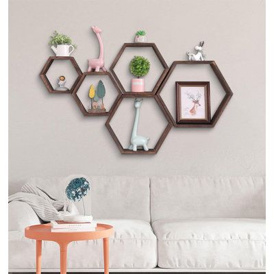 a living room with a white couch and several hexagonal shelves on the wall