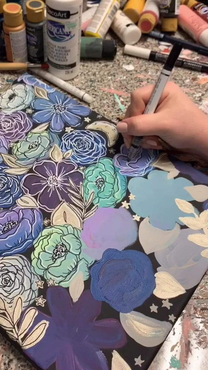 a person is painting flowers on a canvas