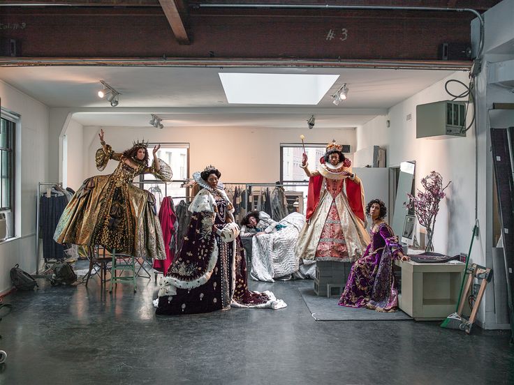 a group of mannequins are dressed up and standing in an art gallery