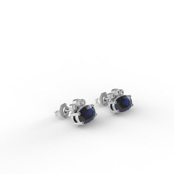 Dress up with these sophisticated pair of Sapphire earrings full of sparkle and chic`They look so perfectly beautiful it's instantly classic.- Made to Order, perfectly finished, Fast shipping fully insured and trackable online.- Sapphire information: Two 6x4mm oval cut Sapphire corundum 1.02 ctw- Diamond information: 6 x Diamonds, VS-E, 0.08 ctw- Arrives gift ready with a certificate of authenticity. Elegant 14k Gold Earrings With Gemstones, Elegant 14k Gold Gemstone Earrings, Elegant Round Cut Diamond Cluster Earrings, Classic Diamond Gemstone Earrings, Elegant Yellow Gold Cluster Earrings In Sterling Silver, Classic Diamond Cut Earrings For Evening, Elegant Yellow Gold Sterling Silver Cluster Earrings, Elegant Oval Diamond Cluster Earrings, 14k White Gold Earrings With Gemstone