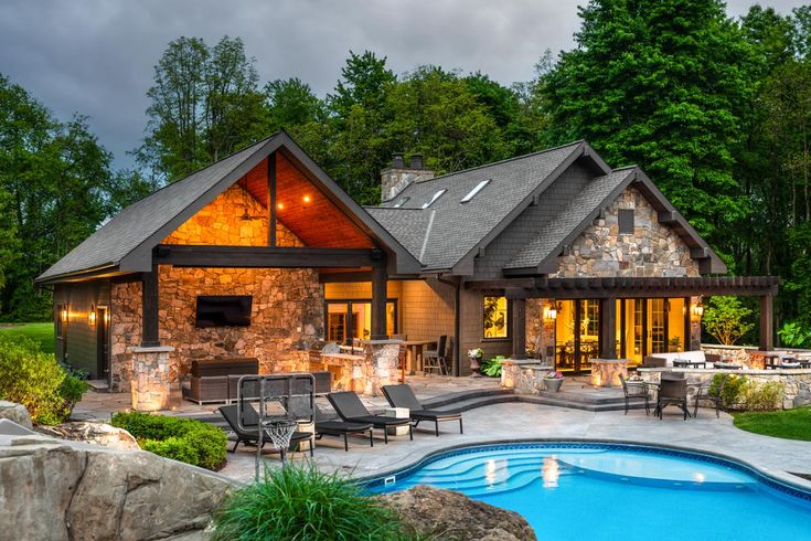 a house with a pool in front of it and an outdoor kitchen on the other side