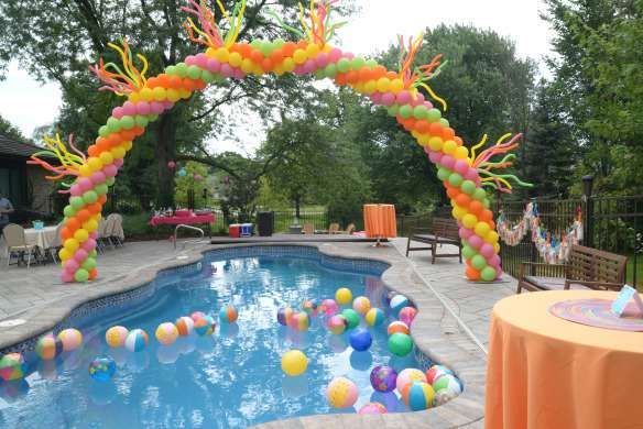 an outdoor pool decorated with balloons and streamers