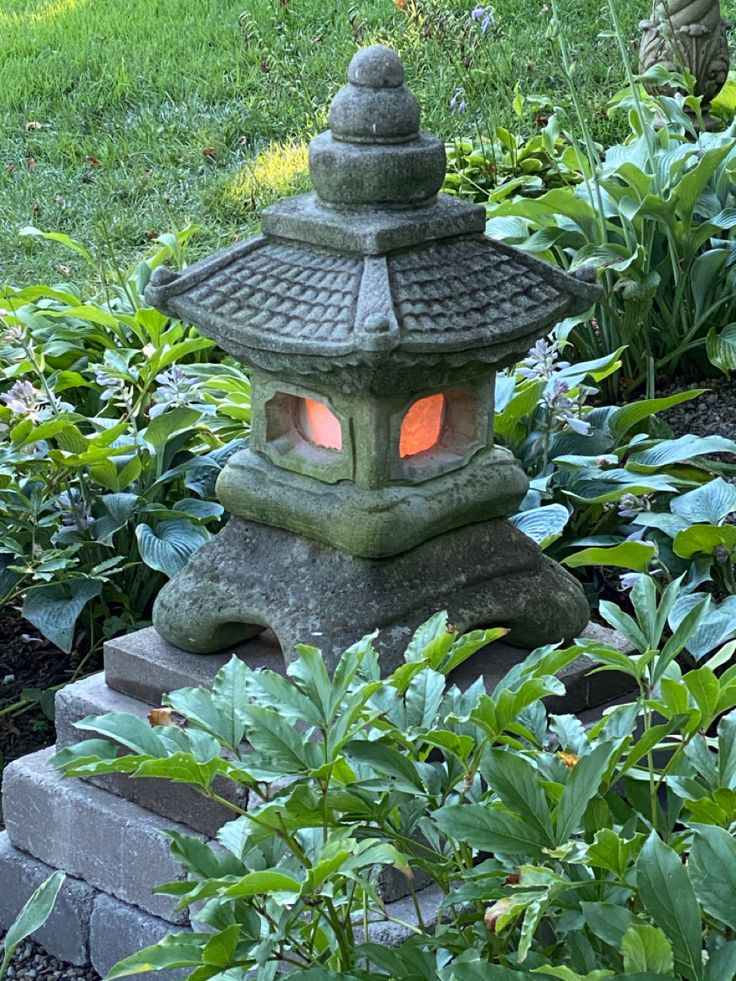 a stone lantern sitting in the middle of a garden