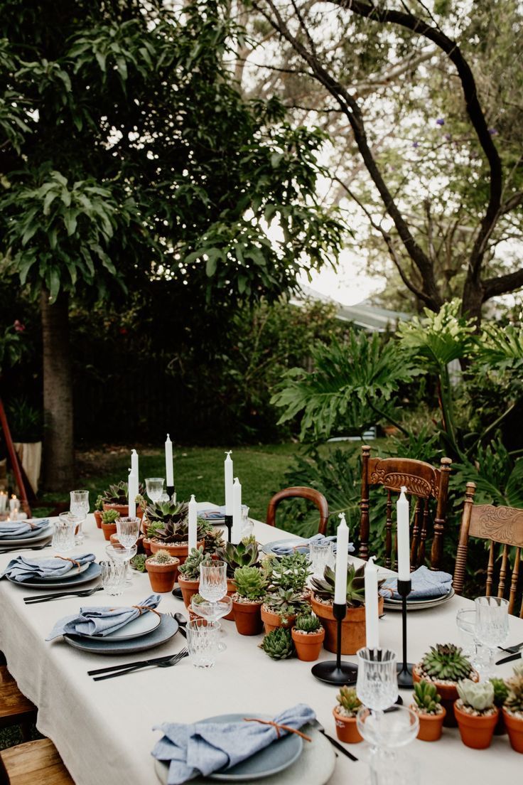 an outdoor table set with plates and place settings