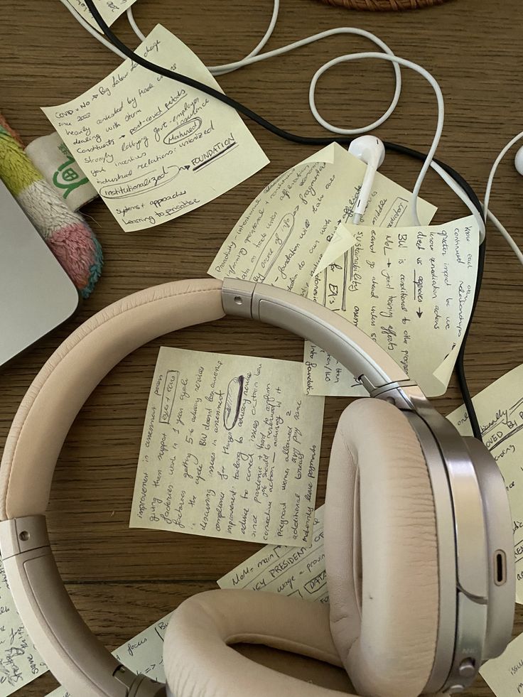 headphones and papers on a table with a laptop