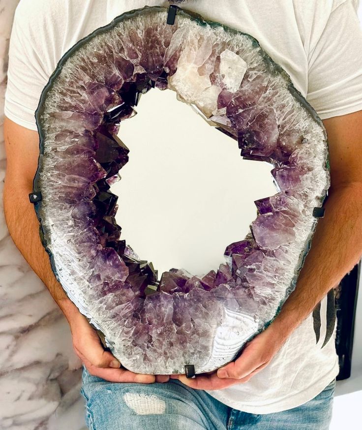 a man holding a mirror with ametholite on it