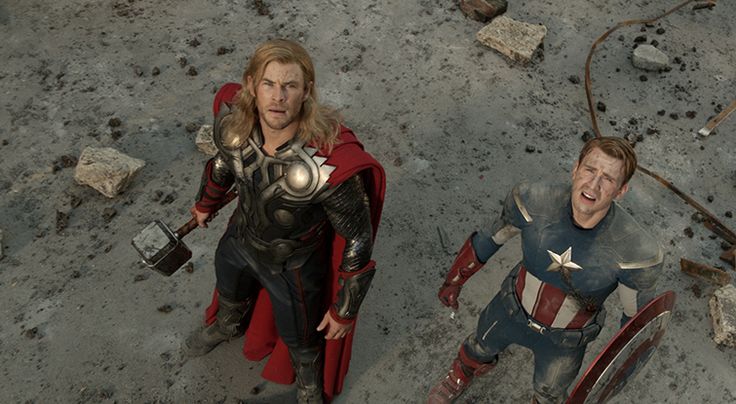 two men dressed as captain america and thor in the middle of an area with rubble