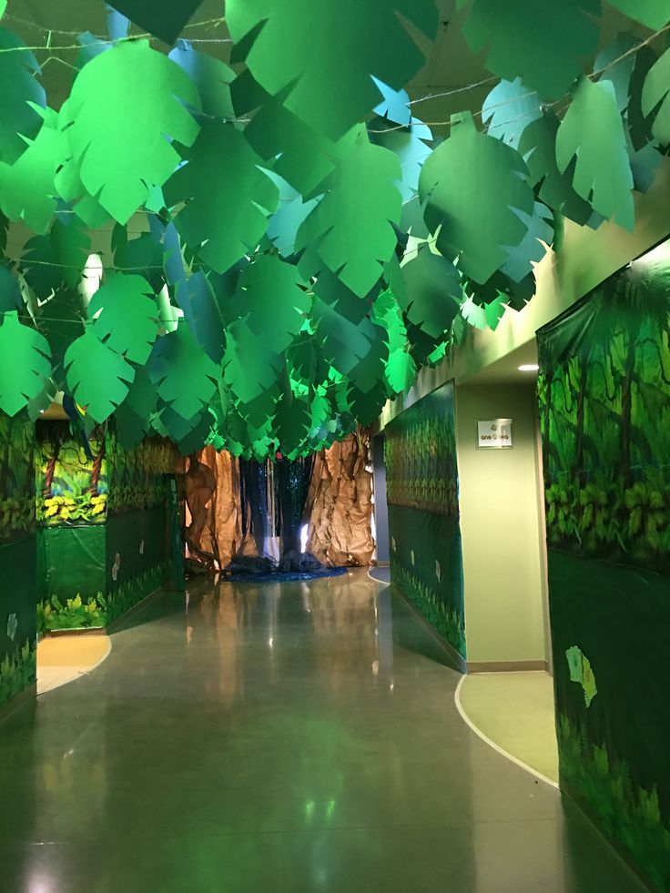 the hallway is decorated with green paper leaves and water features on both sides, along with a waterfall in the center