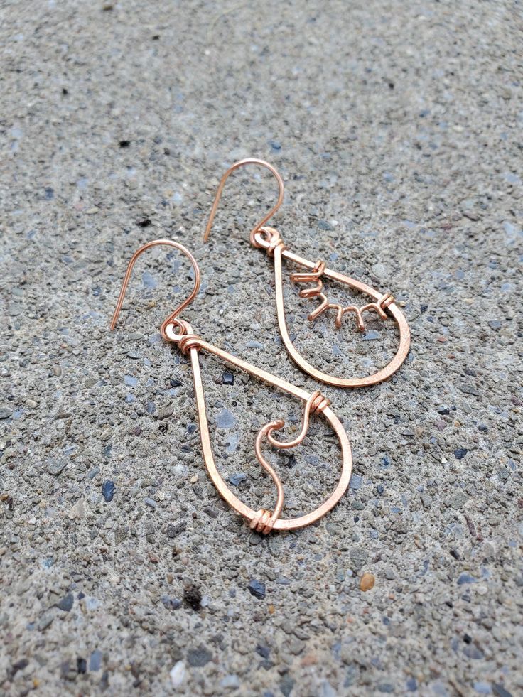 two pairs of earrings sitting on the ground