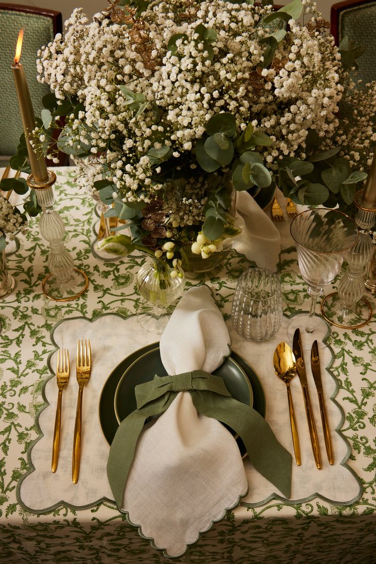 a table set with place settings and flowers