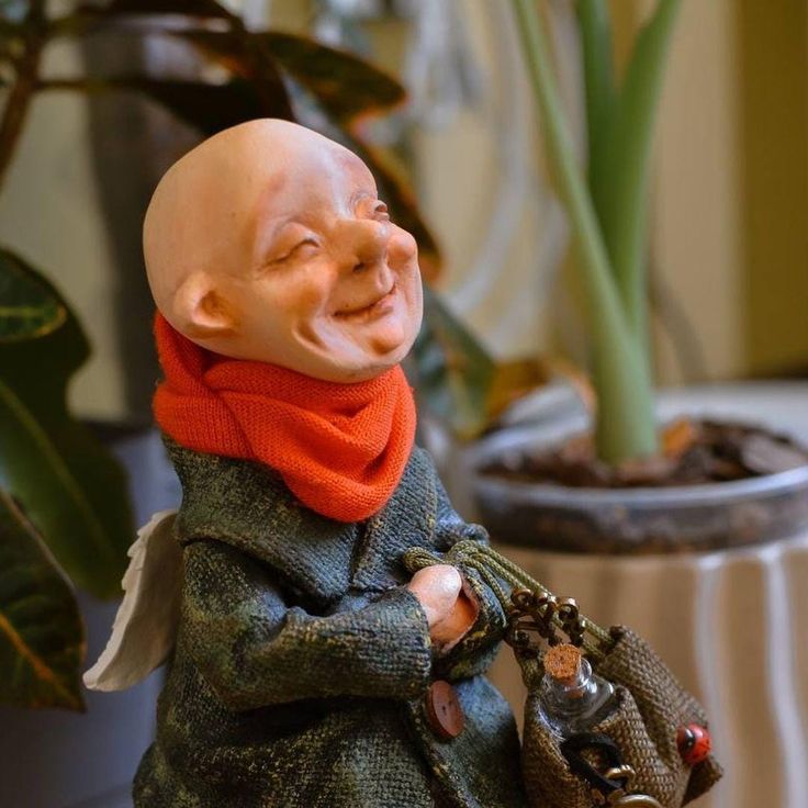 a statue of a smiling man holding a purse