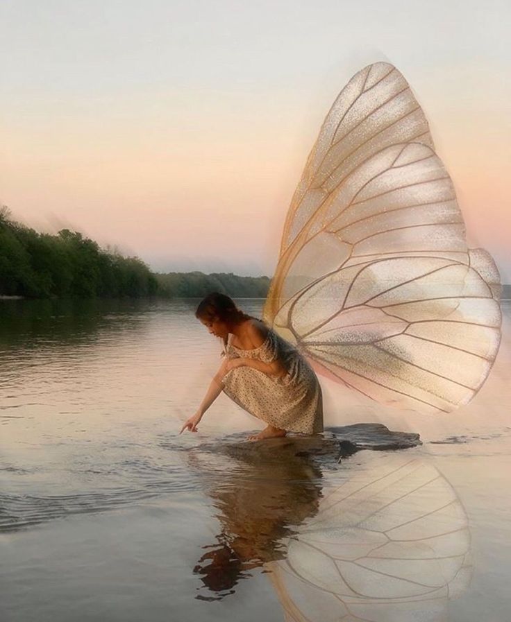 a woman is standing in the water with a butterfly wings on her head and body