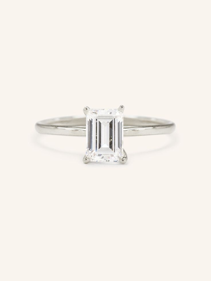 Capture timeless elegance with our Classical Solo Emerald Step Cut Solitaire Engagement Ring. Featuring a classic emerald cut moissanite, this exquisite design is sure to make a statement. Its understated luxury exudes sophistication and elegance, promising to capture your love for eternity. Classic Silver Emerald Ring Gia Certified, Classic Moissanite Emerald Ring For Anniversary, Classic Silver Gia Certified Emerald Ring, Timeless Moissanite Emerald Ring With Brilliant Cut, Timeless Radiant Cut Emerald Ring, Classic 14k Gold Radiant Cut Ring, Classic 14k Gold Ring With Radiant Cut, Classic Diamond White Emerald Ring With Brilliant Cut, Classic Emerald Cut Ring With Prong Setting