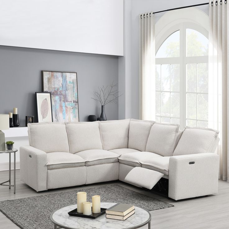 a living room with a sectional couch and coffee table in front of a large window