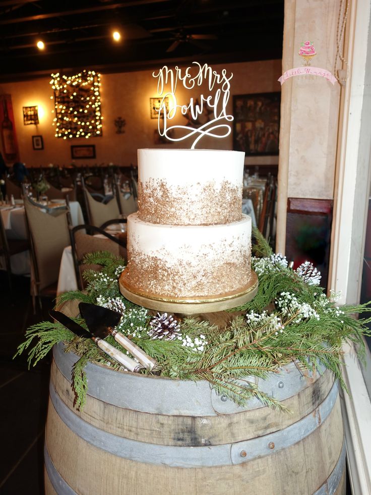 a wedding cake sitting on top of a barrel