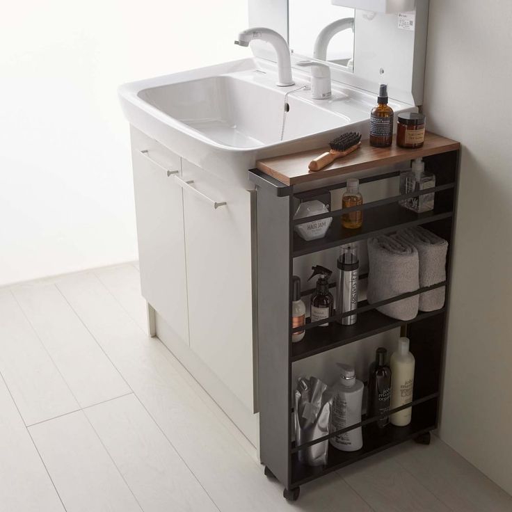 a bathroom sink sitting under a mirror next to a cabinet