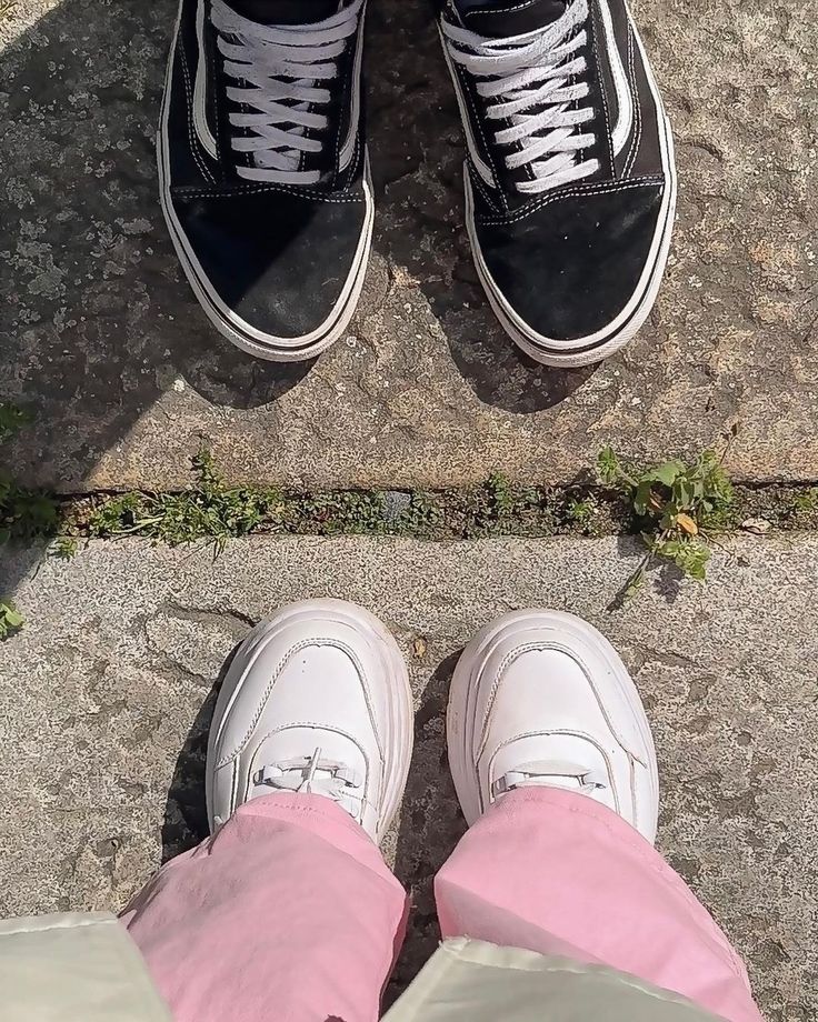 two people standing next to each other wearing black and white shoes with pink pants on