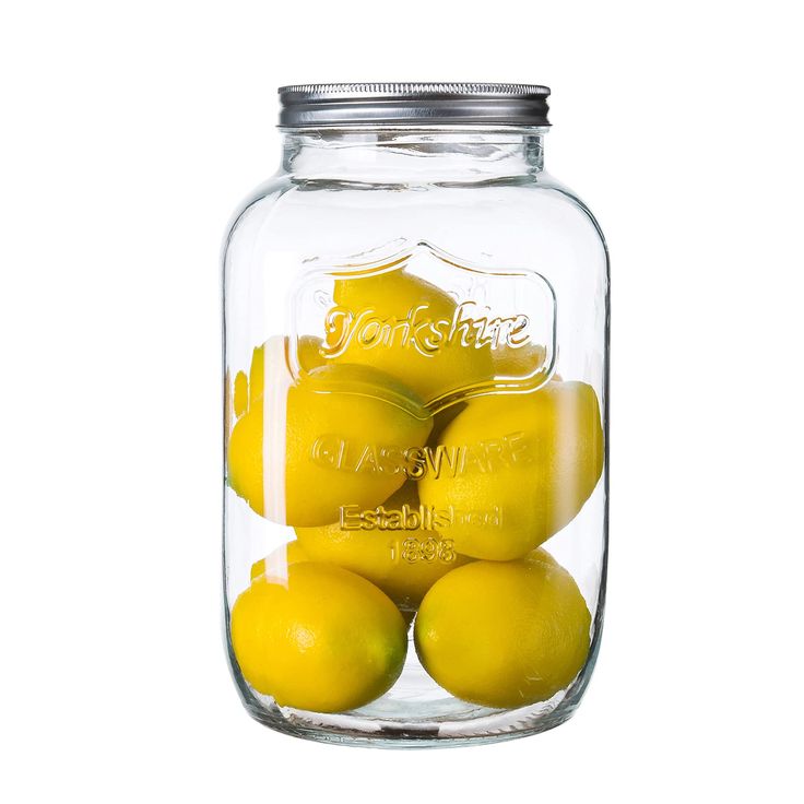 a glass jar filled with lemons sitting on top of a table