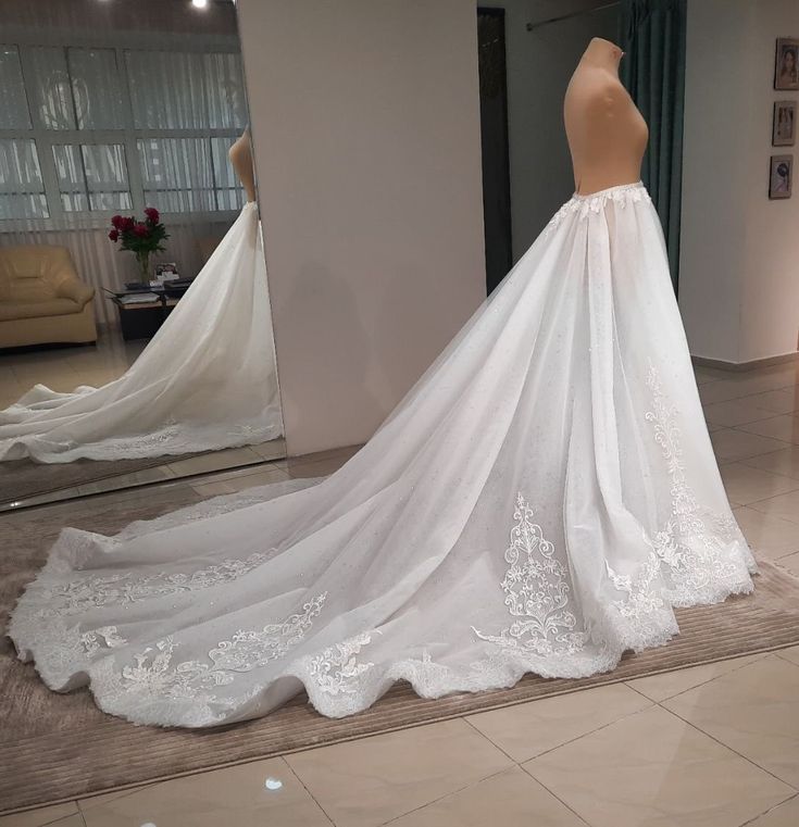 a wedding dress on display in front of a mirror