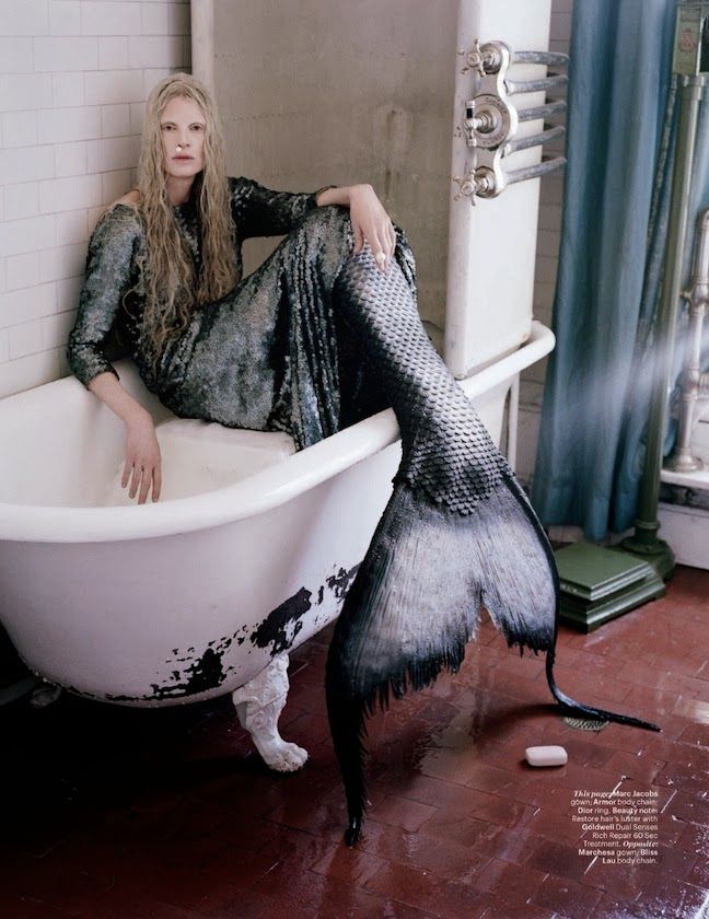 a woman sitting in a bathtub with her legs spread out