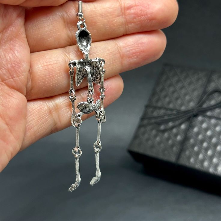 Get ready to dance the night away with these one-sided skeleton earrings in a vintage metallic silver finish! Perfect for any occasion - Halloween, Day of the Dead, a birthday party, or a night out with friends. Lightweight, articulated (all limbs are movable) and beautifully detailed, these earrings make a unique and original gift for yourself or someone special. Add some gothic, punk, and tattoo fashion to your look with these playful and quirky CALACAMANIA™ accessories Earrings details: Size: Punk Skull Earrings For Party, Punk Style Hand Cast Halloween Jewelry, Gothic Skull Earrings For Party, Nickel-free Skull Jewelry For Party, Silver Skull Earrings For Halloween, Spooky Silver Pierced Earrings, Silver Metal Jewelry For Costume Party, Spooky Silver Nickel-free Earrings, Spooky Nickel-free Silver Earrings