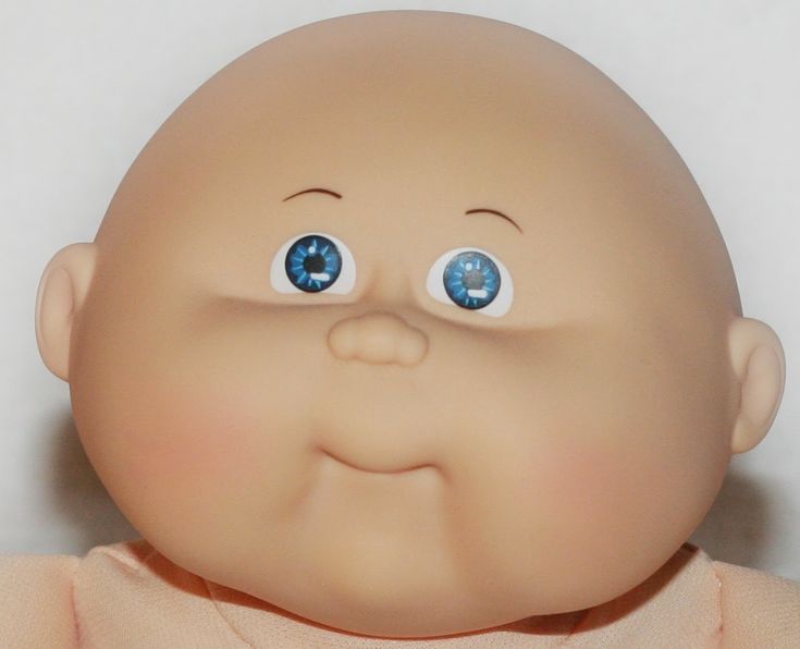 a close up of a baby doll with blue eyes