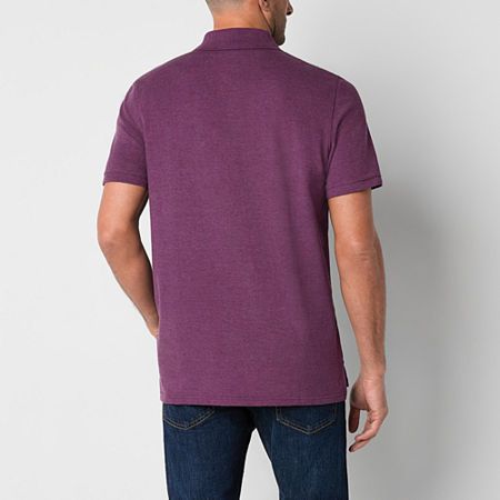 a man in a purple shirt is looking down at the back of his head while wearing jeans