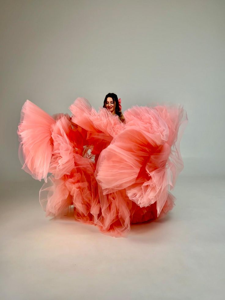 a woman in a pink dress is posing for the camera