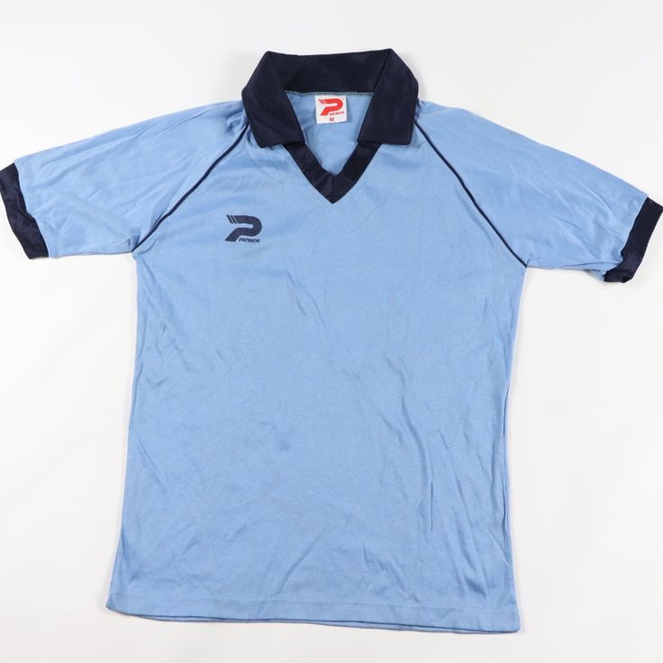 a light blue shirt with black trim on the collar and two contrasting sides, showing an embroidered logo