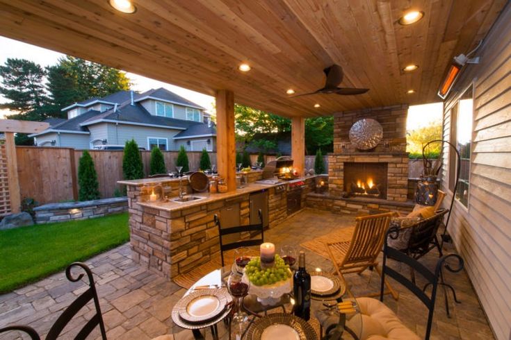 an outdoor kitchen and dining area is lit up