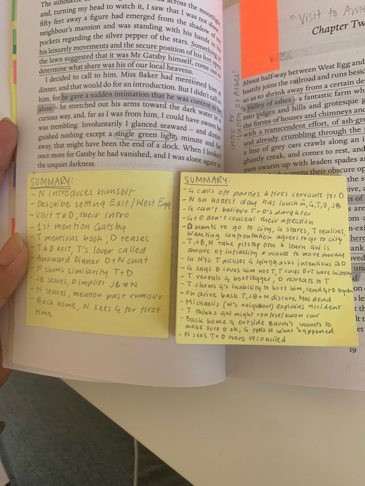 an open book with sticky notes attached to it and someone's hand holding one