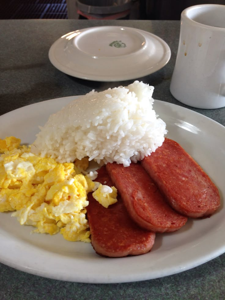 a white plate topped with eggs, sausage and rice