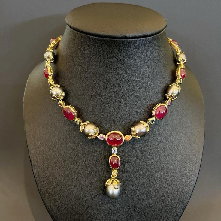 This is part of Chairish’s Fine Jewelry assortment.  Natural Red Ruby 54 Carats South Sea Oval shape Tahiti Pearls Natural Sapphires - 9 Carats 18K Yellow Gold  This Necklace is from the "Baroque" collection and it is the epitome of elegance and versatility and offers a perfect blend for day to night and swimwear to evening wear, allowing you to effortlessly transition between different occasions and outfits. Wearing this will undoubtedly make you the center of attention. It has a rich history g Pearl And Ruby Necklace, Luxury Red Cabochon Necklaces, Luxury Red Cabochon Necklace, Luxury Oval Necklace For Ceremonial Occasions, Luxury Ruby Jewelry With Rose Cut Diamonds, Luxury Ceremonial Ruby Jewelry, Luxury Ruby Jewelry For Ceremonial Occasions, Ceremonial Luxury Ruby Jewelry, Traditional Cabochon Necklace For Formal Occasions