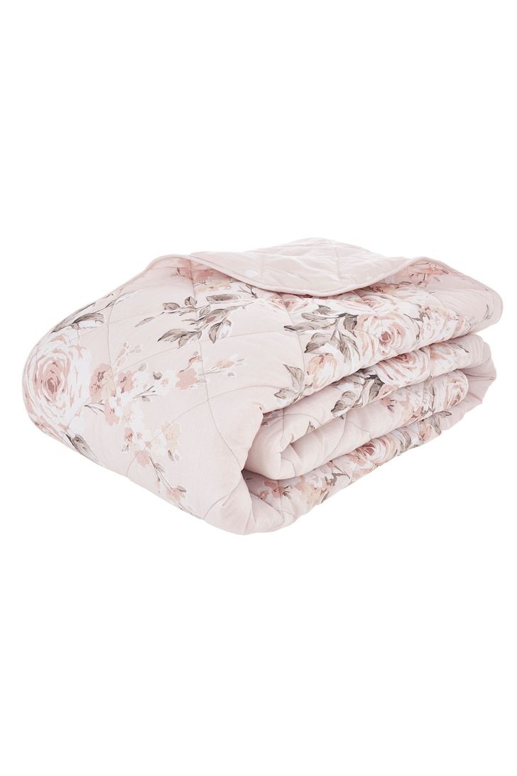 the pink floral blanket is folded on top of each other