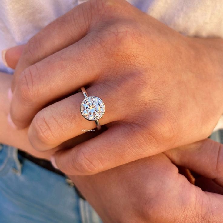 a close up of a person wearing a diamond ring