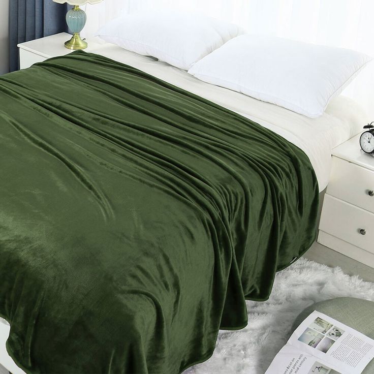 there is a green blanket on the bed