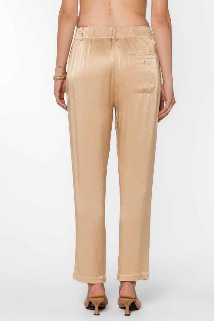 Expertly crafted with pull-on design, Sherona Pants combine luxurious satin material with functional features such as fly front and belt loops. Enjoy ultimate comfort and convenience in these elegant pajama pants. Material: 100% Viscose Color: Sesame Hand wash or dry clean Model is 5'9'' and is wearing a size S Imported Elegant Gold Silk Bottoms, Chic Satin Ankle-length Bottoms, Silk Bottoms With Elastic Waistband And Straight Leg, Elegant Silk Bottoms With Relaxed Fit, Elegant Satin Ankle Pants, Chic Tapered Leg Loungewear Pants, Casual Silk Straight Leg Pants, Chic Tapered Leg Pants For Loungewear, Chic Silk Bottoms With Elastic Waistband