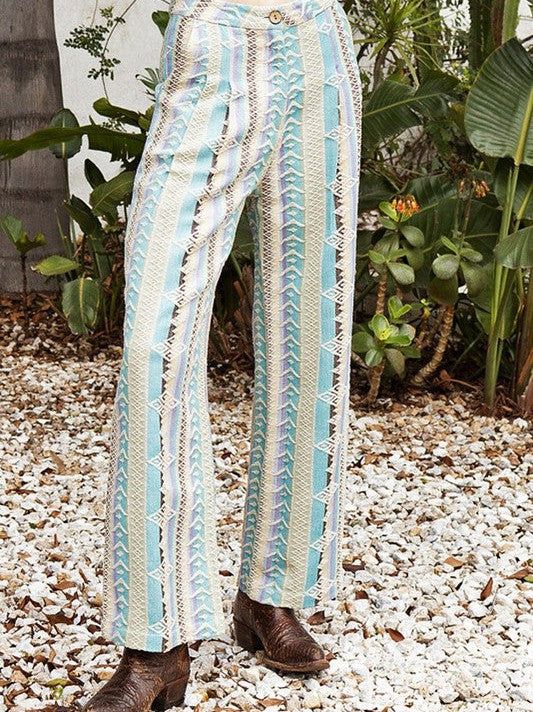 Step into summer style with these unique multicolor embroidered pants. Made in India, each pair features a trendy design and wooden button, adding a touch of quirkiness to your wardrobe. Stay cool and fashionable all season long! Color: Summer Fabric: 100% Cotton Includes: x1 Pants Sizes: XS-XL, Regular Sizing. Model is 5'8" and is wearing a size S. Spring Hippie Straight Leg Bottoms, Hippie Straight Leg Spring Bottoms, Hippie Style Straight Leg Bottoms For Spring, Hippie Style Straight Leg Spring Bottoms, Trendy Cotton Wide Leg Pants For Vacation, White Rayon Bottoms For Vacation, White Hippie Bottoms For Summer, Green Cotton Wide Leg Vacation Pants, Green Cotton Wide Leg Pants For Vacation