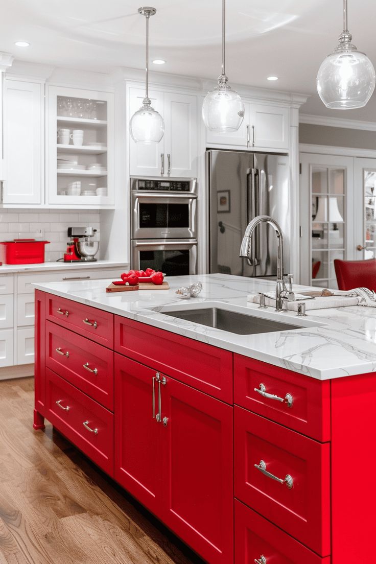 a kitchen with red cabinets and marble counter tops, stainless steel appliances and an island in the middle