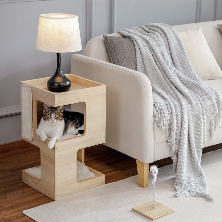 a cat is sitting in the corner of a small wooden table next to a couch