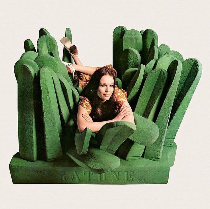 a woman laying on the back of a giant green chair that is shaped like a plant