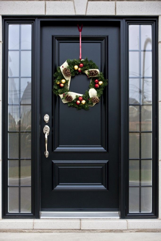 a black front door with a wreath on it