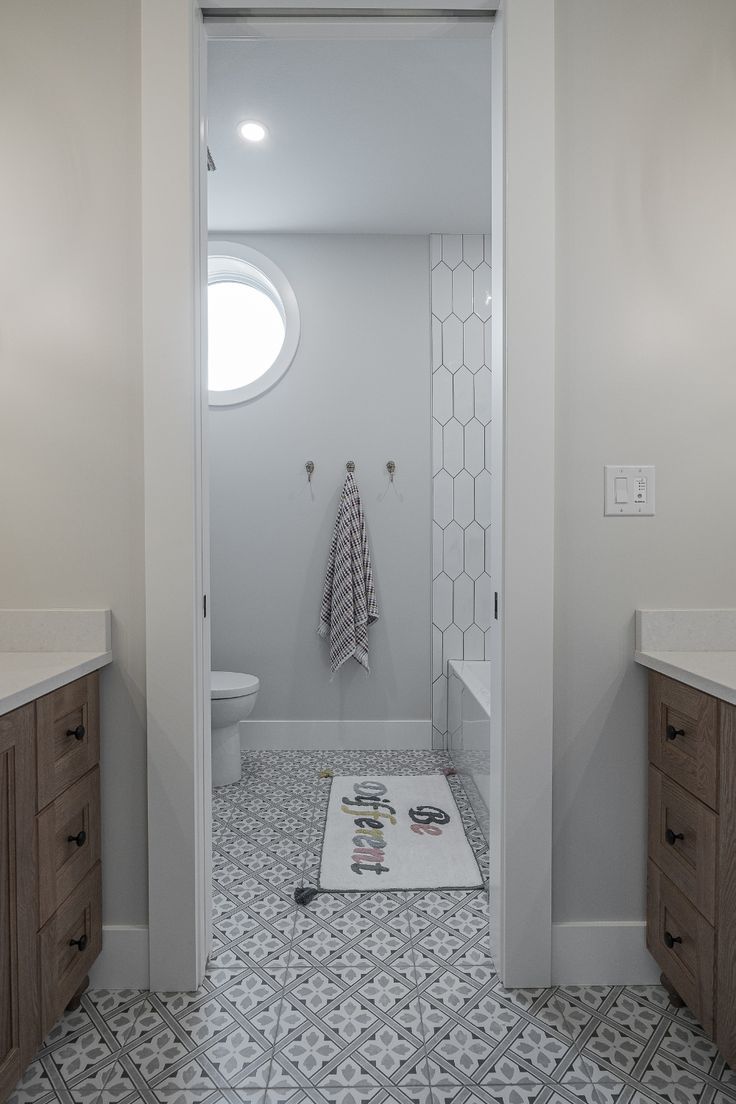 a bathroom with white walls and grey flooring