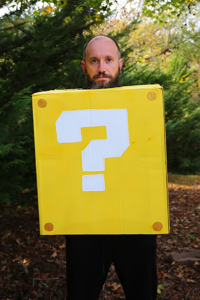 a man holding a yellow sign with a question mark on it