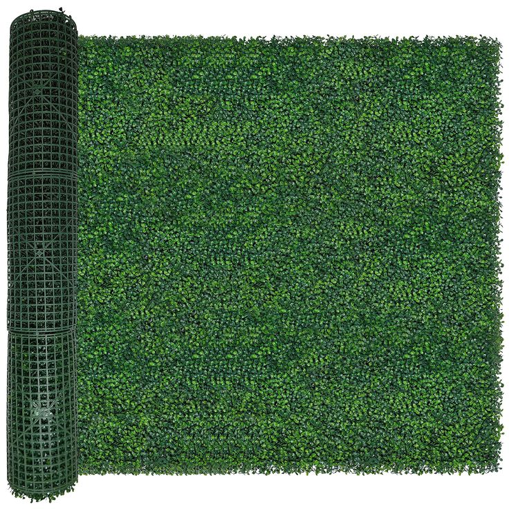 a roll of green grass on top of a white surface with a mesh fence around it